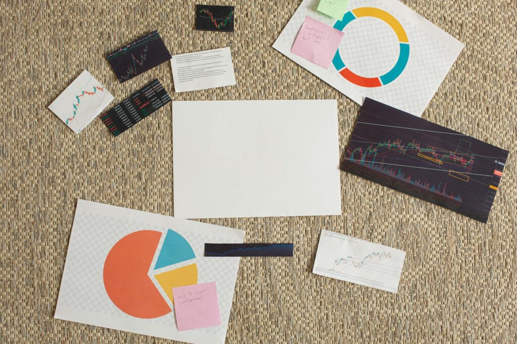 Flat lay of financial charts and sticky notes on a textured surface, ideal for planning and analysis concepts.